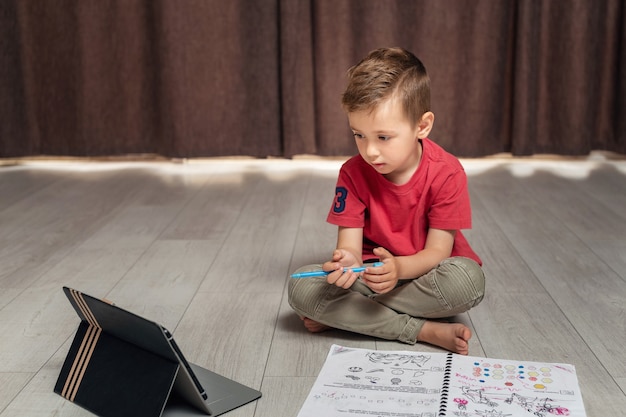 Portrait of little boy using digital tablet at home.