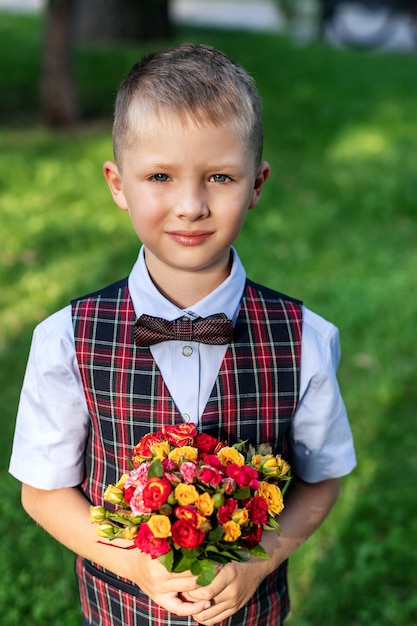 Photo portrait little boy with bouquet of flowers