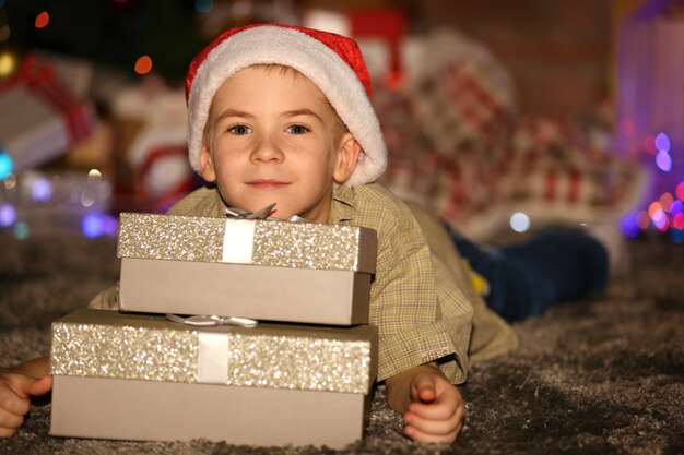 Foto ritratto di un ragazzino con scatole regalo su uno sfondo sfocato