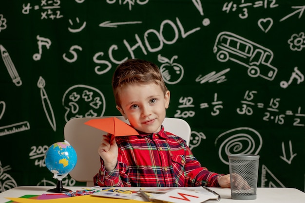 Portrait of a little boy with a paper plane