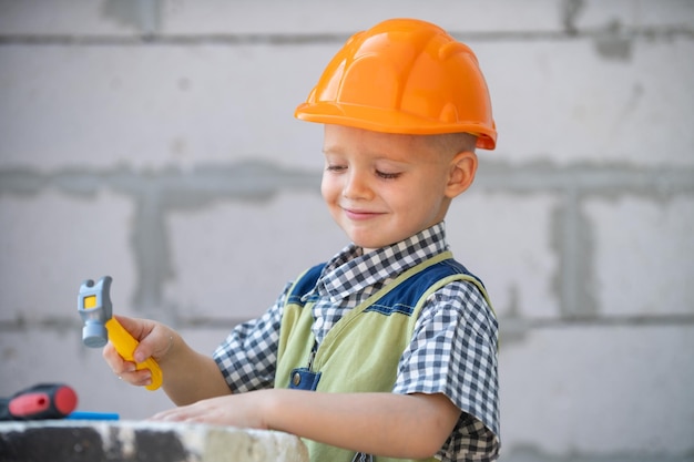 Portrait of little builder in hardhats with instruments for renovation on construction Builder boy carpenter kid with builder tools set Repair home