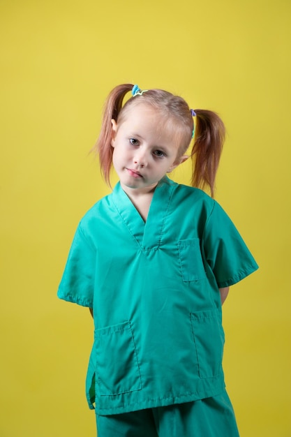 Портрет маленькой кавказской девочки, одетой в зеленое пальто врачей