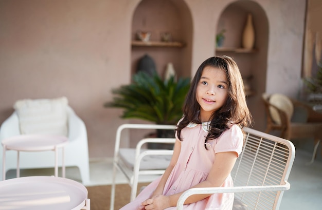 Portrait of little child smiling and looking at camera. Smiling Asian Girl Enjoying at cafe.