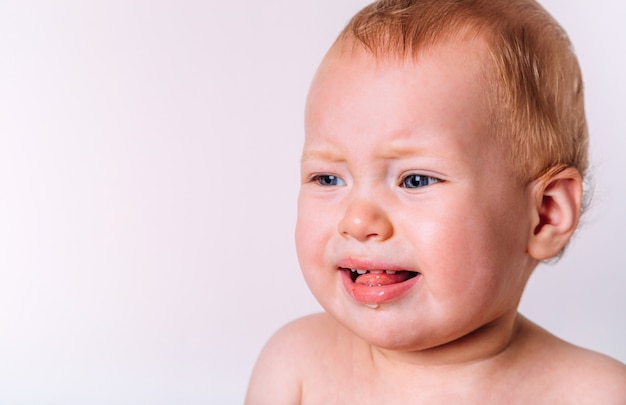 Portrait of a little cute baby emotionally crying and screaming. Isolated on a white background.