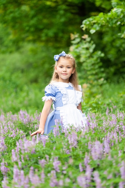 Portrait of a little cute girl dressed as Alice. Stylized photo shoot in nature.