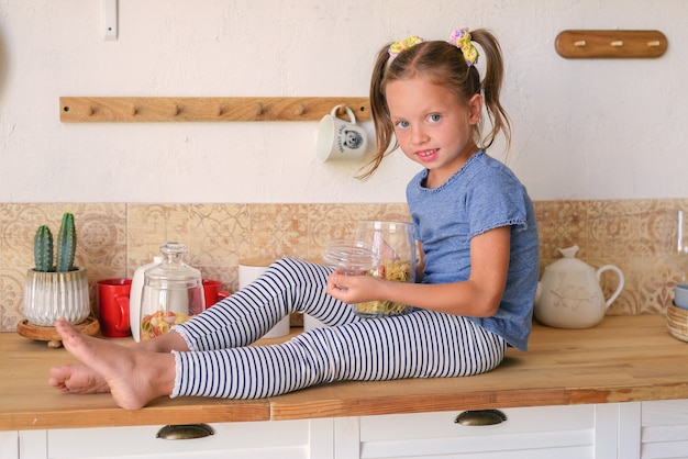 portrait of a little cute girl in the kitchen with groceries and healthy food