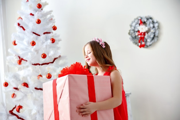 Portrait of little cute girl with Christmas present