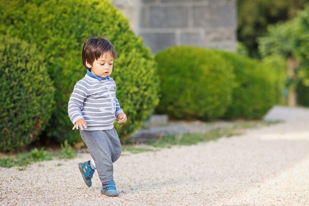 公園で屋外で遊ぶ小さな東部のハンサムな男の子の肖像画