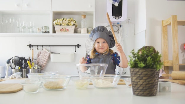 Portrait of little girl baker on kitchen close up