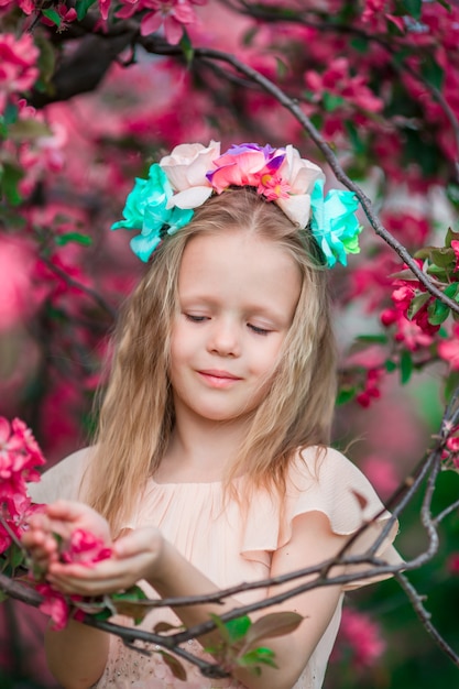 Ritratto della bambina nel bello giardino di mele di fioritura all'aperto