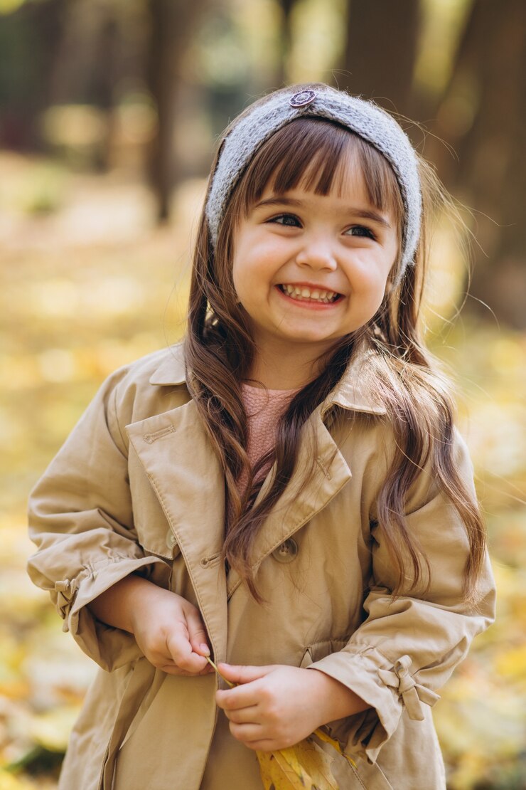 Photo ベージュのコートを着た肖像画の少女が秋の公園を歩く