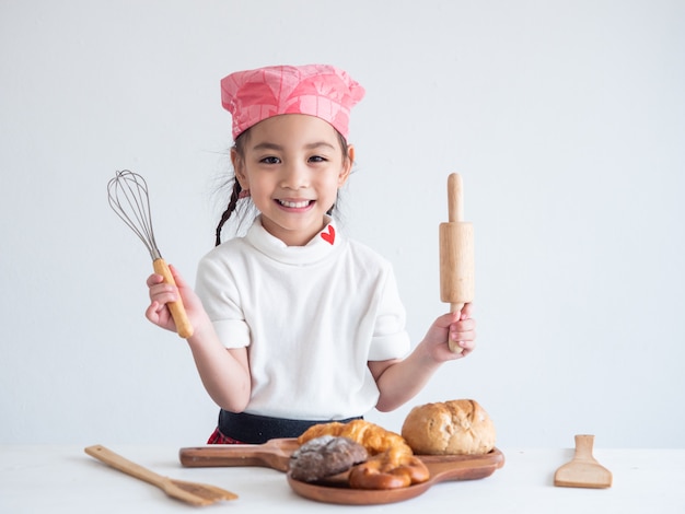 Photo portrait of a little girl cooking