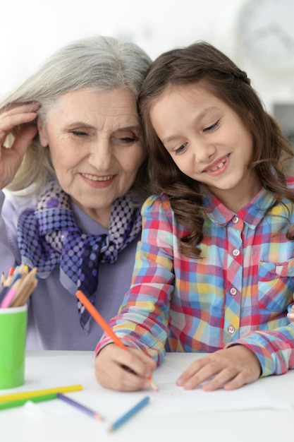 Portrait of Little girl drawing with her grandmother