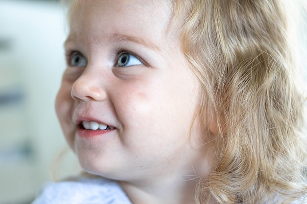 Portrait of a little girl, the girl looks to the side and smiles.