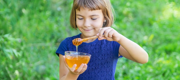 Portrait of a little girl holding a bowl with honey