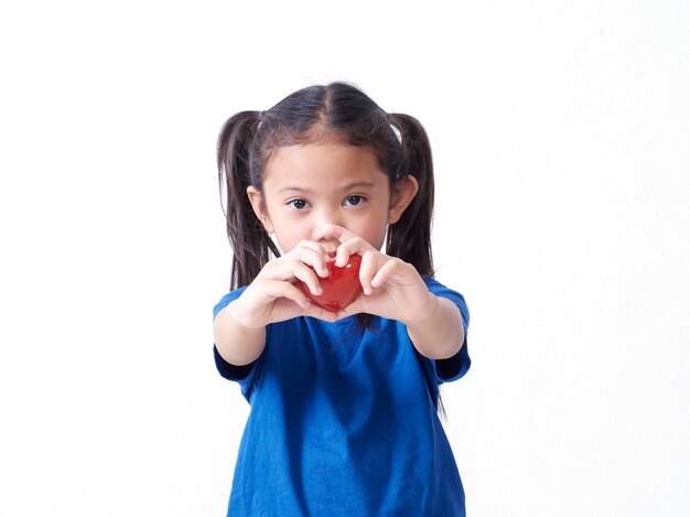 Portrait of little girl holding red heart on white background. Space for text