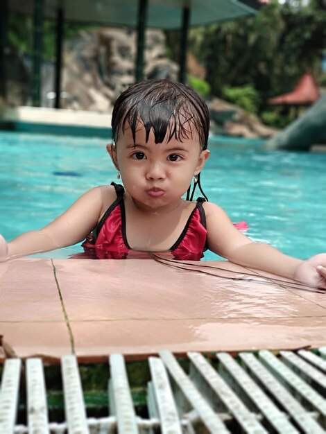 Portrait of little girl looking away while swiming