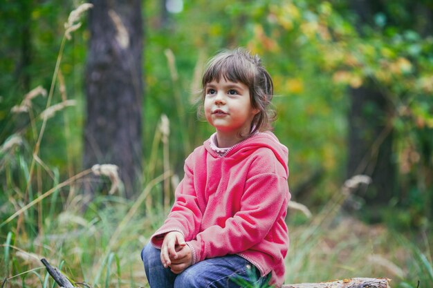 Foto ritratto di una ragazzina all'aperto nella foresta d'autunno