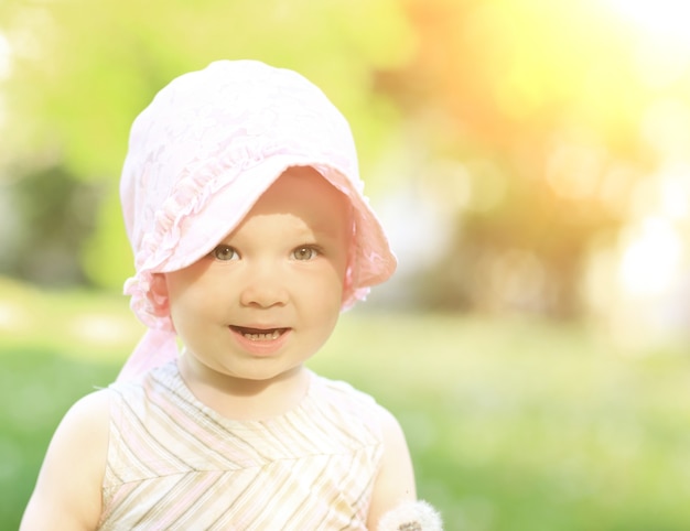 Portrait of a little girl in a panama in the park on a sunny day