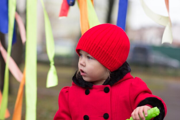 Portrait of little girl in the red outside looking aside