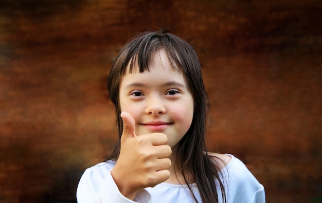 Portrait of little girl smiling on brown background