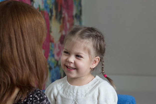 Portrait of little girl smiling and looking at her mother