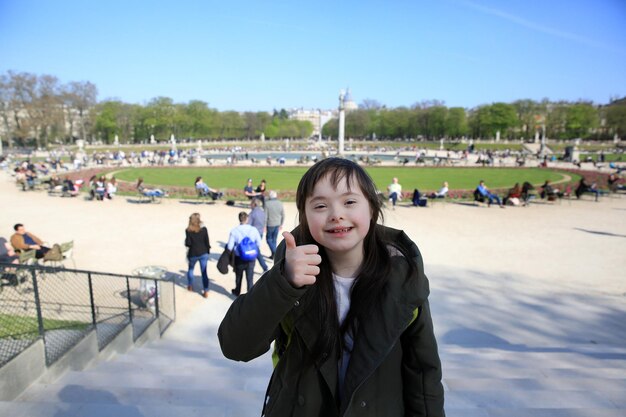 Portrait of little girl smiling in Luxembourg Gardens, Paris