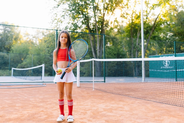 Portrait of a little girl on the tennis court