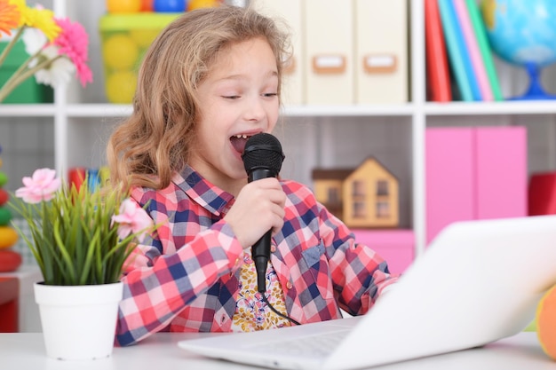 Portrait of little girl using modern laptop