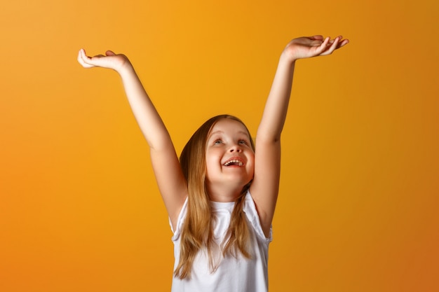 Photo portrait of a little girl with arms raised.