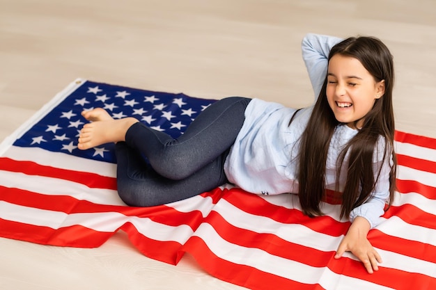 Portrait of a little girl with the flag of America. American education, study in America.