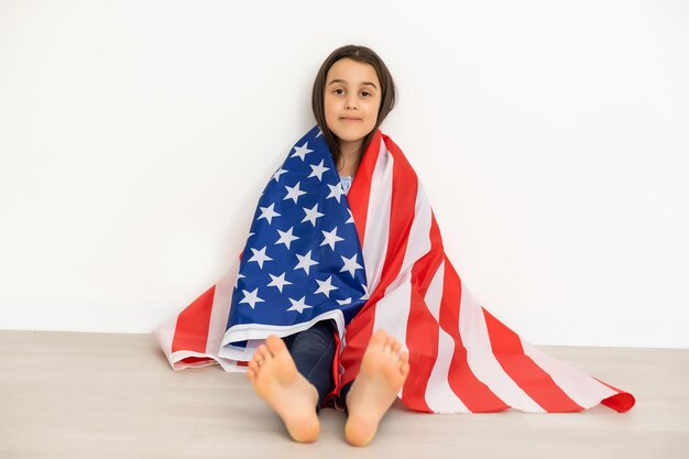 Portrait of a little girl with the flag of America. American education, study in America.