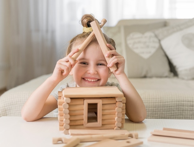 Portrait of little girl with house model.