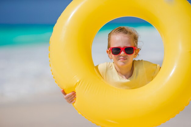 Portrait of little girl with inflatable rubber circle on beach vacation