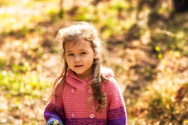 portrait of a little girl with long hair in the forest