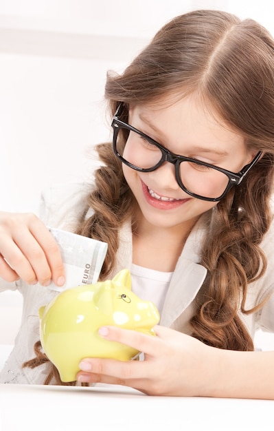 Portrait of little girl with piggy bank and money