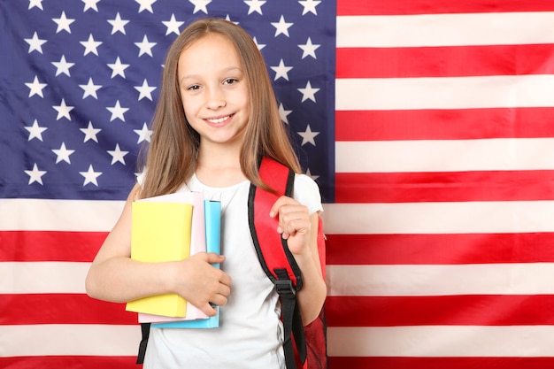 Photo portrait of a little girl with a school backpack and flag of america