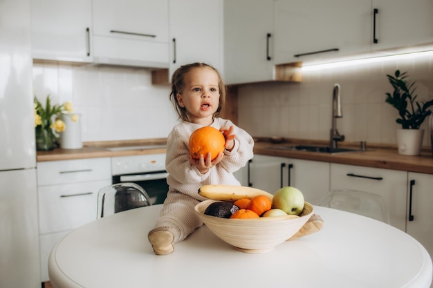 Portrait of a little girl with sweet pepper Playing in the kitchen