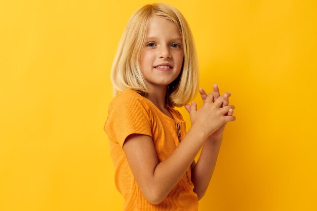 Portrait of a little girl in a yellow tshirt smile posing studio childhood lifestyle unaltered