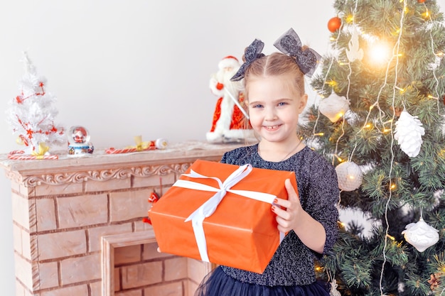 Portrait of little happy cute girl with Christmas present.