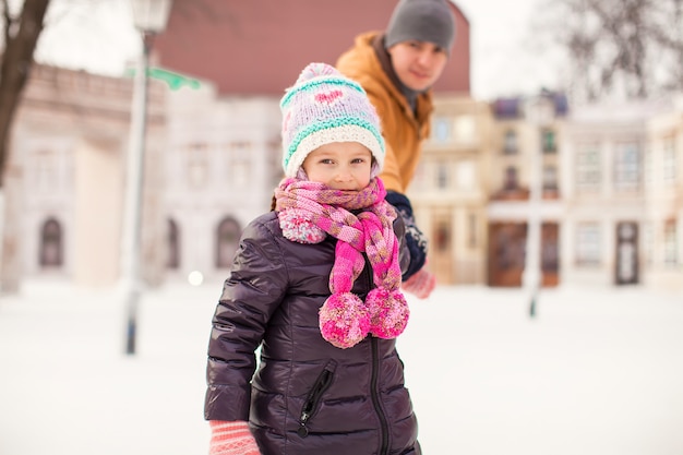 Portrait of little happy girl enjoys skating with her father