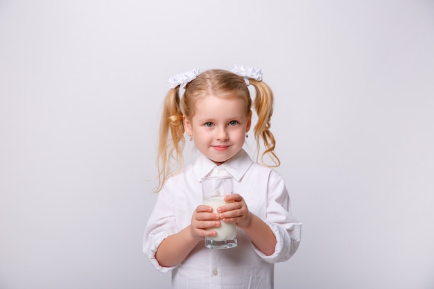 Портрет маленькой счастливой девушки с стеклом молока.