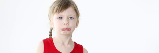 Portrait of little offended girl on white background children manipulations and whims concept