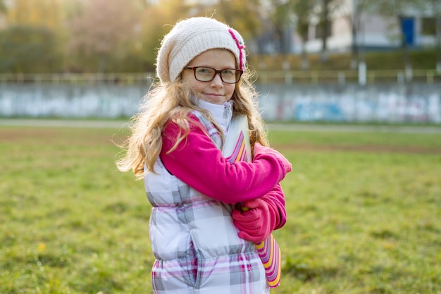 Portrait of little schoolgirl on sunny autumn day