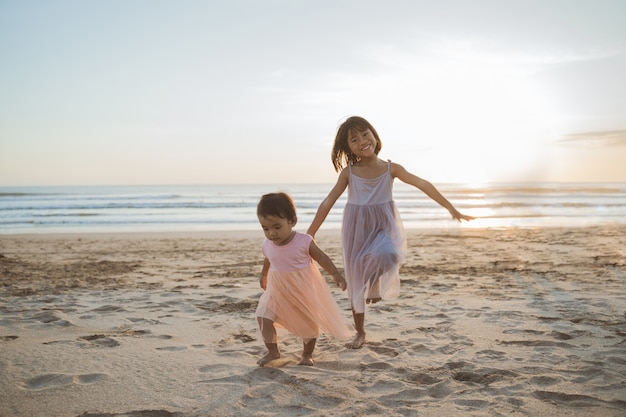 Портрет маленьких сестер, наслаждающихся отдыхом на пляже