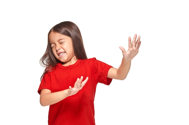 Портрет маленькой удивленной девушки, взволнованной и испуганной в красной футболке. Изолированные на белом фоне