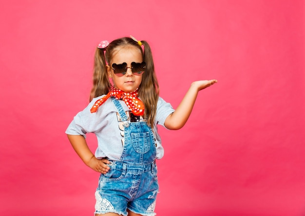 Foto ritratto di un piccolo adolescente in occhiali da sole che mostra palma e classe. figli.