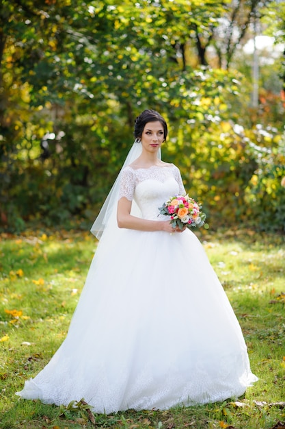 Portrait of a lonely bride on a background of an autumn park