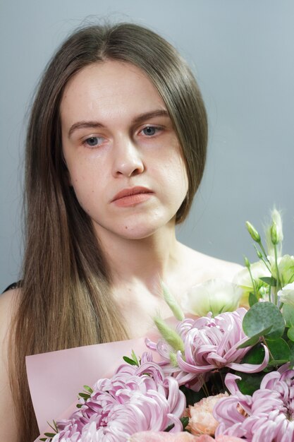 Portrait of long-haired brunette girl with beautiful summer bouquet