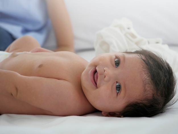 Ritratto bel bambino sorridente felicemente sul letto